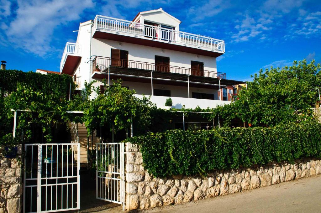 a white building with a fence in front of it at House Iliskovic in Hvar