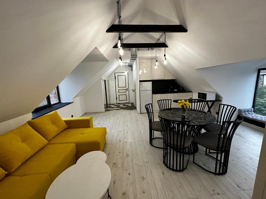 a living room with a yellow couch and a table at Areguni Cottage in Dilijan