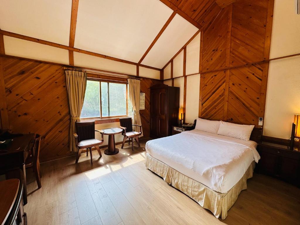 a bedroom with a bed and a table and chairs at Ivy Motel in Chiayi City