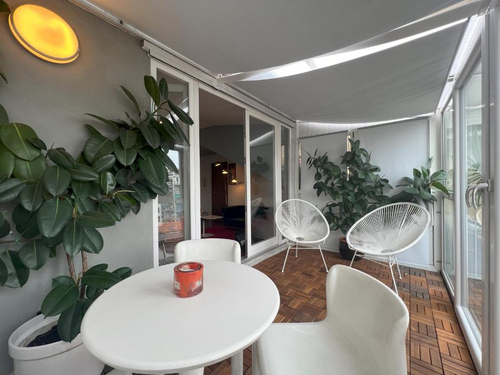Biały stół i krzesła w pokoju z roślinami w obiekcie La terrazza - DESIGN APARTMENTS in Turin w Turynie