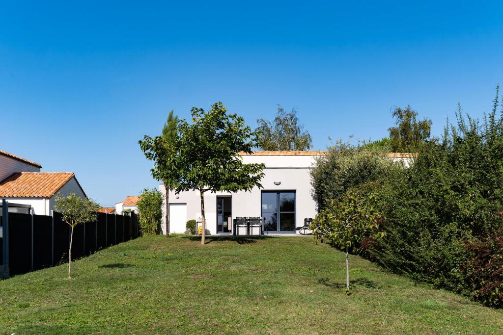 una casa blanca con un patio con árboles en gîte de Marko et Mag à Oudon, en Oudon