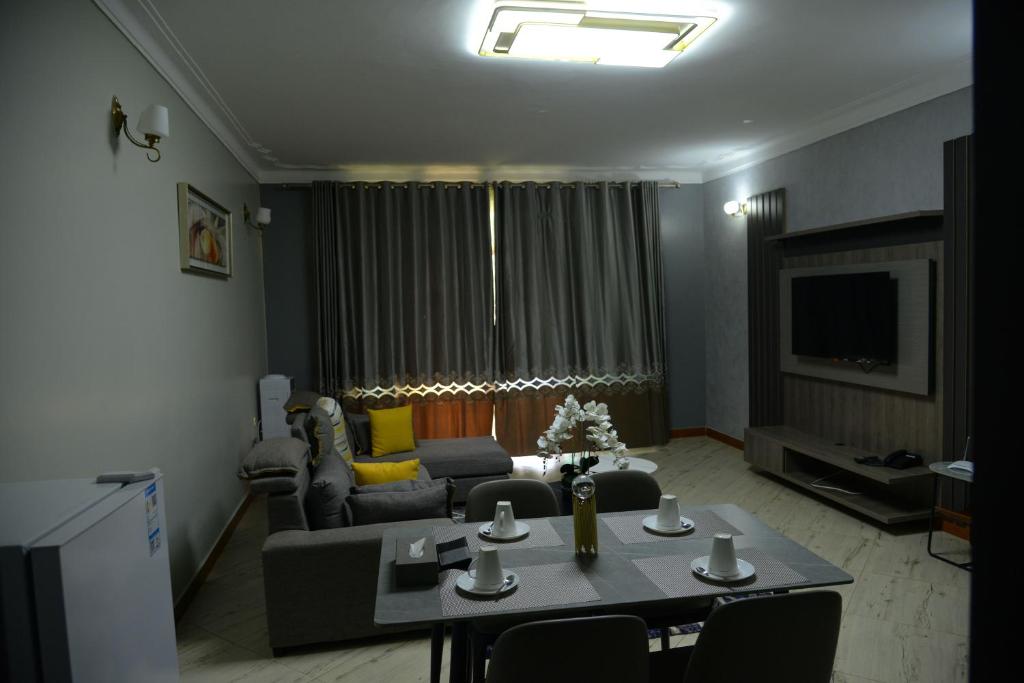 a living room with a couch and a table at Entebbes Trendy 3 Bedroom Suite in Namulanda