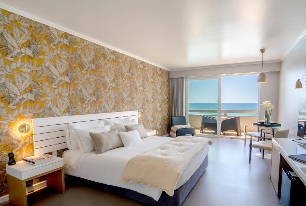 a bedroom with a large white bed with a wall at Arribas Sintra Hotel in Sintra