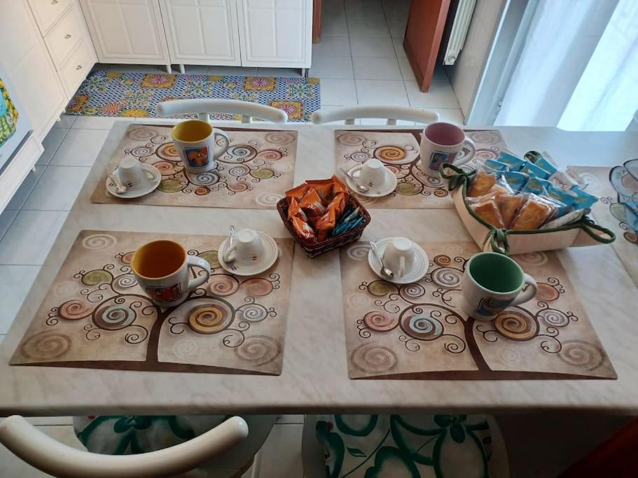 un tavolo con tazze e piattini sopra di Il nespolo a Barcellona Pozzo di Gotto