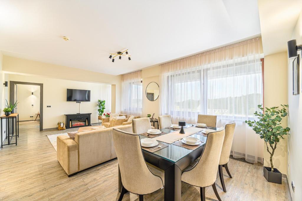 a dining room and living room with a table and chairs at B41 Apartment Poiana Brasov in Poiana Brasov