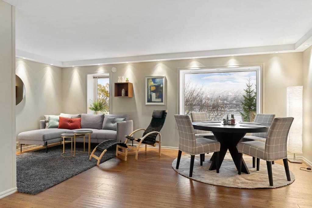 un salon avec un canapé, une table et des chaises dans l'établissement Cozy elegant 2bedroom apt w/parking and nice view, à Tromsø