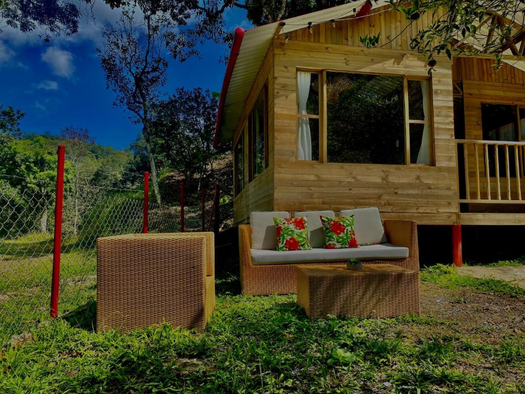 a tiny house with a couch and two pillows at cabañas la vega in La Vega
