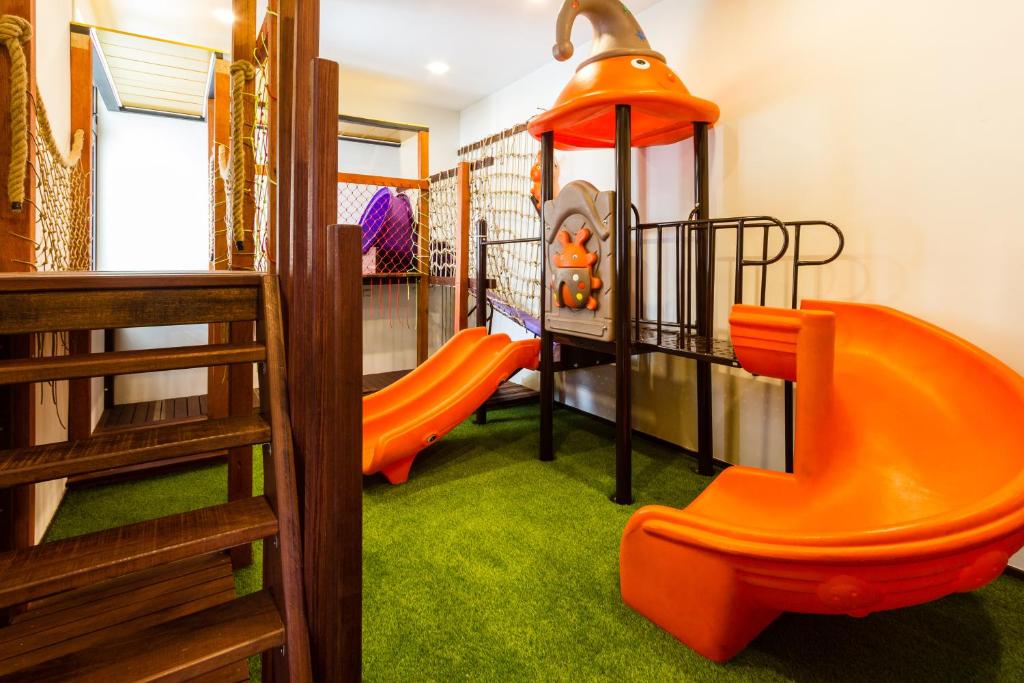 a childrens play room with orange chairs and a slide at Varnen Cozy Haven - EVCharger in Bukit Mertajam