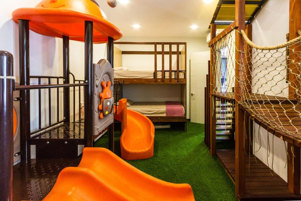 Varnen Cozy Haven في بوكيت ميرتاجام: غرفة مع سرير بطابقين وزحليقة