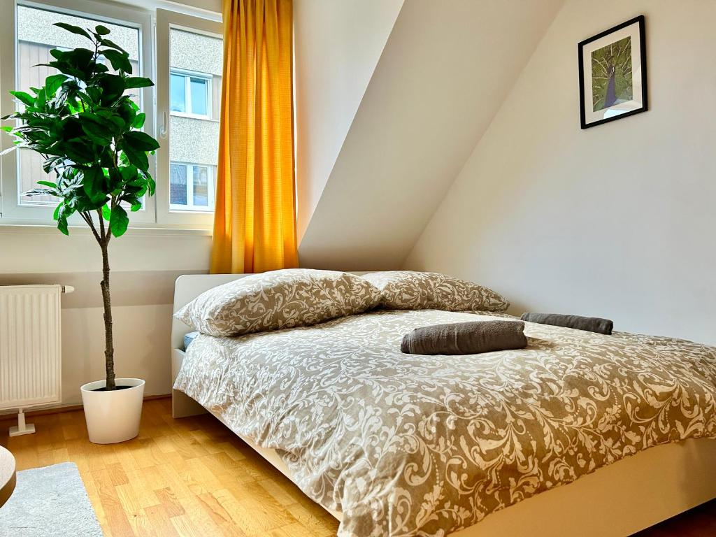 a bedroom with a bed with pillows and a plant at Premium 80 m2 Rooftop Apartment - 5 min to Center in Vienna