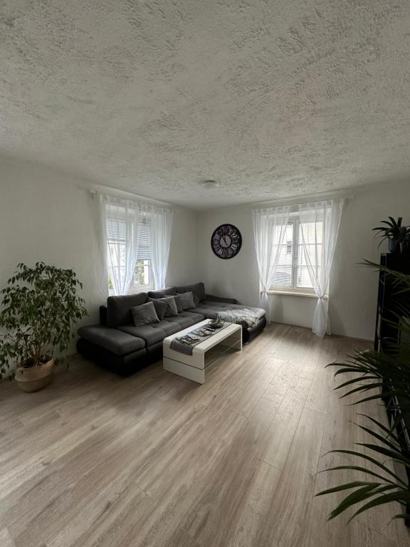 uma sala de estar com um sofá e um relógio na parede em Gemütliche Wohnung in zentraler Lage em Graz