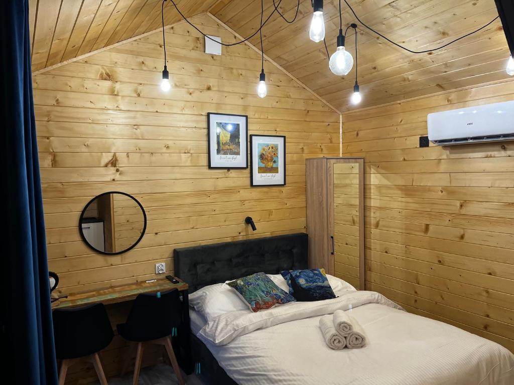 Wypoczynkowa Osada - całoroczne domki 700m od Suntago : غرفة نوم بسرير في جدار خشبي