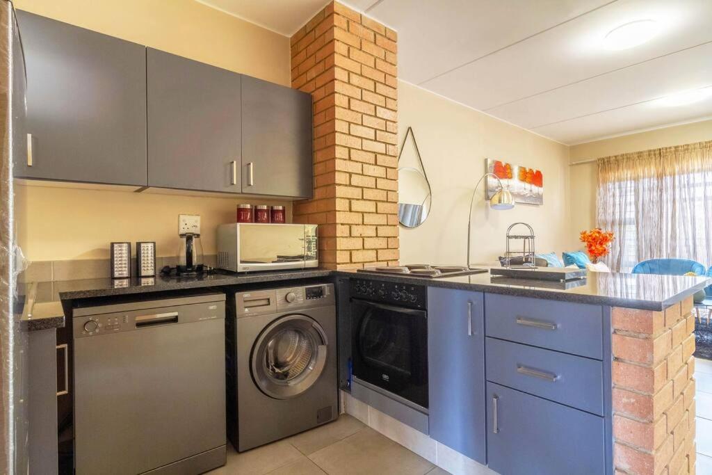a kitchen with a washer and dryer in it at #AlimamaSpaces: Bonito's Waterfall Ridge in Midrand