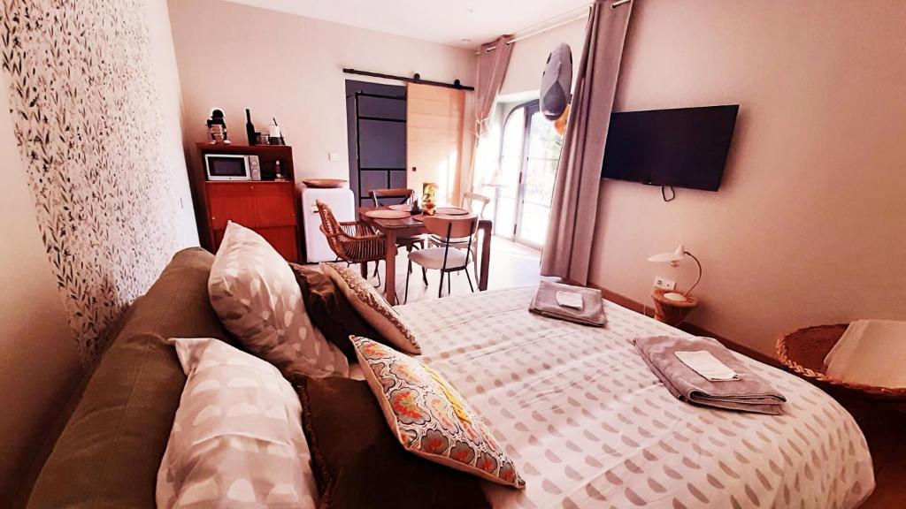 een slaapkamer met een bed en een eetkamer met een tafel bij P'tit cocon au cœur du Lot avec piscine in Dégagnac