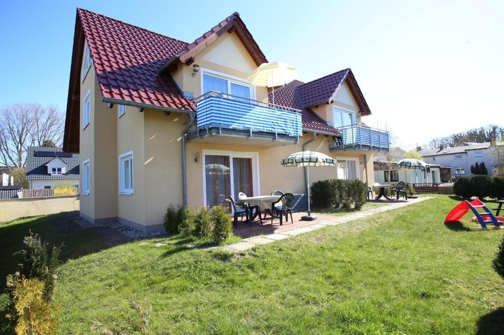 ein Haus mit einem Tisch und Stühlen im Hof in der Unterkunft Ferienhaus Puschmann - FeWo 03 in Zinnowitz