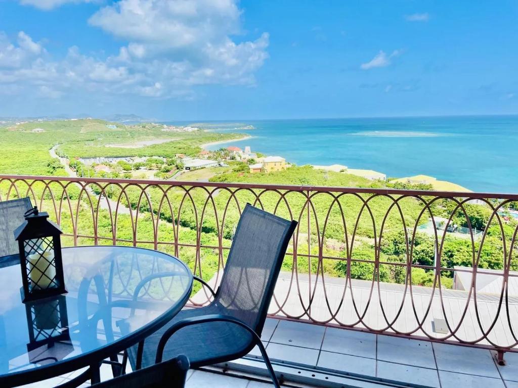 a balcony with a table and chairs and the ocean at St Croix Bliss - Tranquil Retreat-Ocean Views-Island Breezes in Christiansted