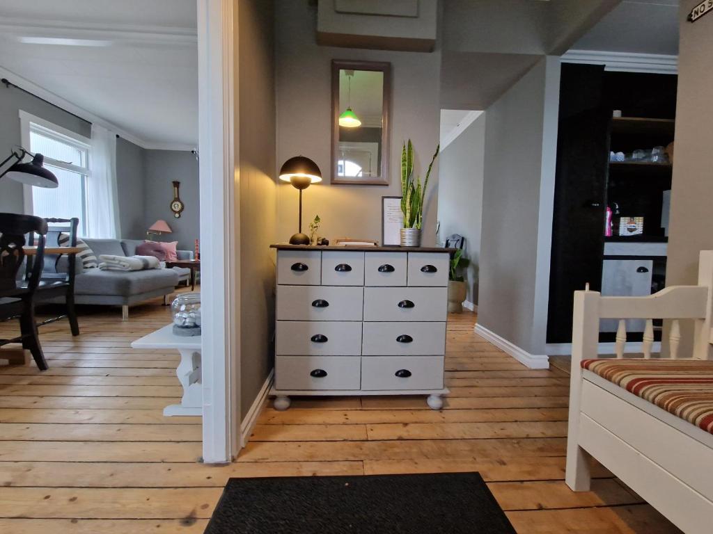 a room with a dresser and a living room at Charming Villa with mountain view in Siglufjörður