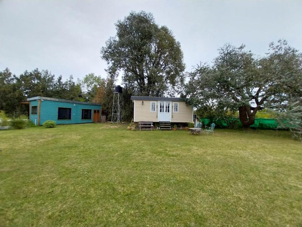 una pequeña casa en un campo con un patio en Las Nativas de Areco en San Antonio de Areco