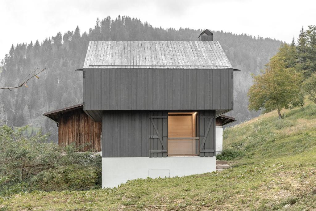 a black and white house on top of a hill at Tabia' Stelo Fiorito in Santo Stefano di Cadore
