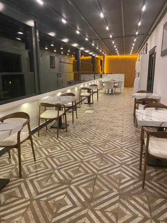 un restaurante con mesas y sillas en un suelo de baldosa en The Rooms Boutique Otel en Kumbağ