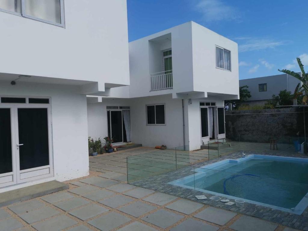 a white house with a swimming pool in front of it at villas andrez in Savinia