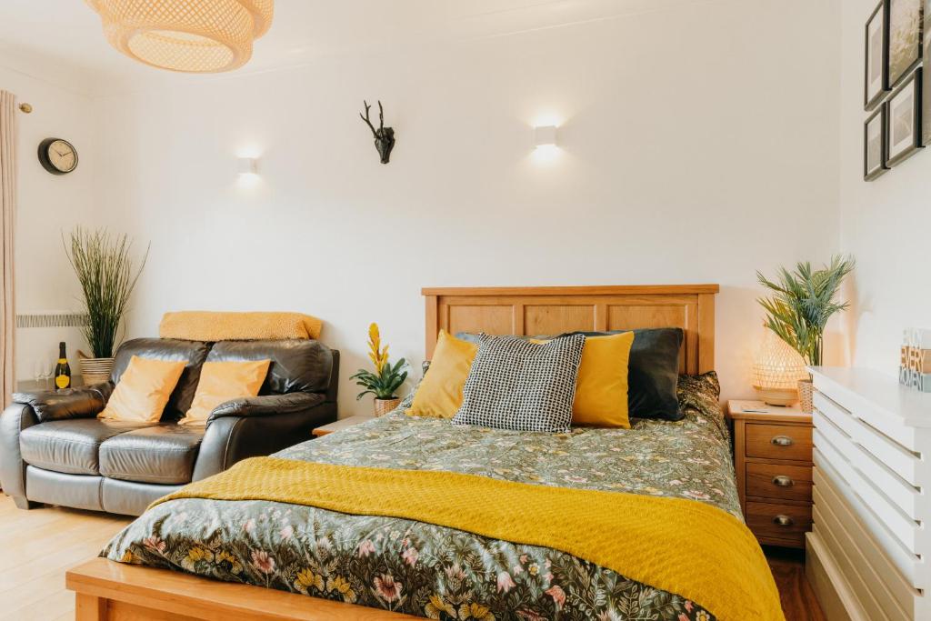 1 dormitorio con 1 cama y 1 sofá en Luxury Private Suite-Parking, Courtyard & Wi-Fi en Caldicot