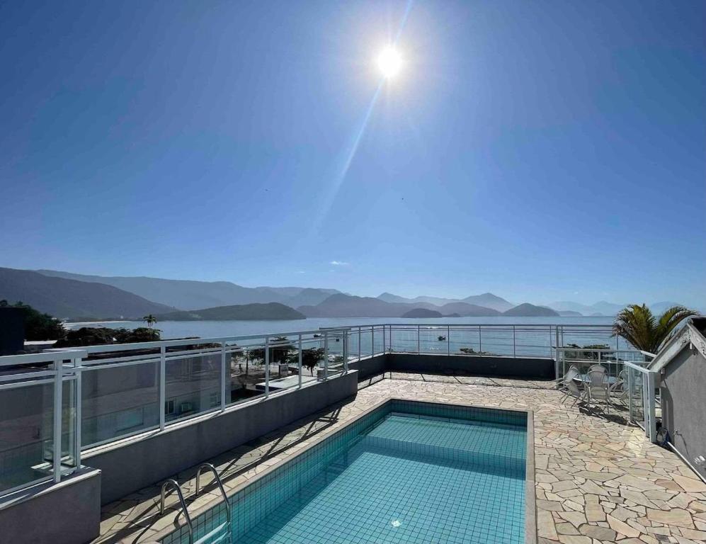 a swimming pool on top of a building with a view of the water at DUPLEX MONTECARLO in Ubatuba