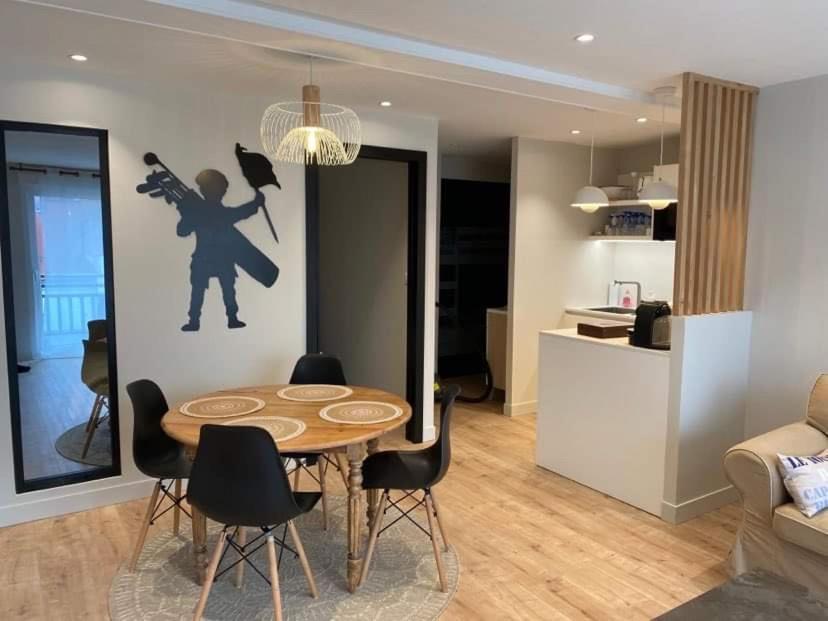 un soggiorno con tavolo e sedie e una cucina di Le Paris Plage a Le Touquet-Paris-Plage