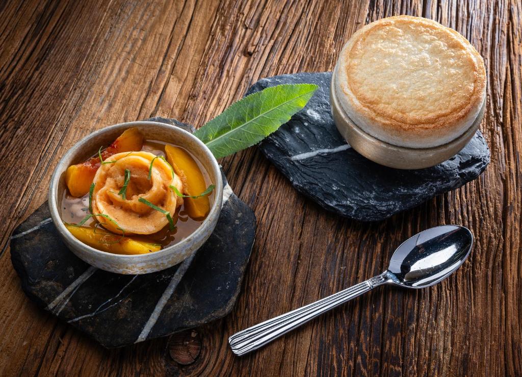 a bowl of food on a table with a spoon at Au Coin Du Feu in Megève