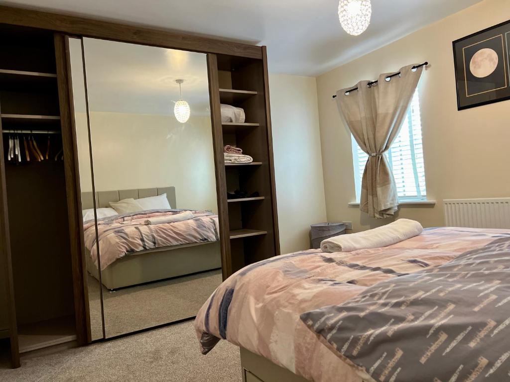 een slaapkamer met een spiegel naast een bed bij Comfort Home in Gillingham