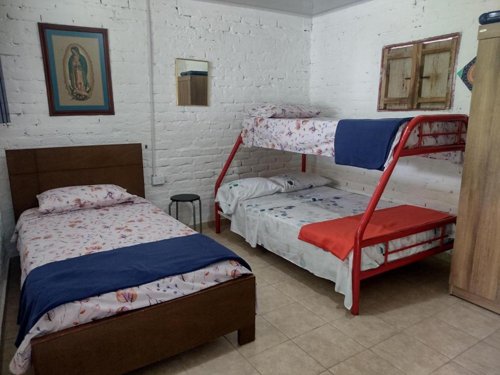 1 dormitorio con 2 camas y 1 litera en FINCA LA COLONIA en Buga