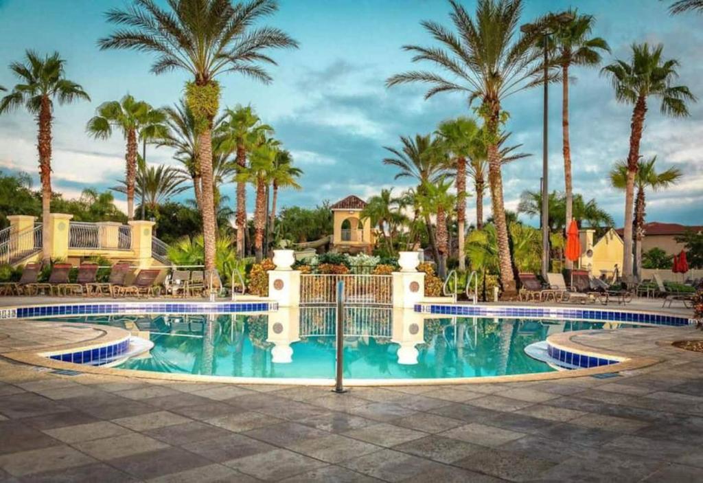 una piscina en un complejo con palmeras en Beautiful 4 Bedroom Vacation Home at Regal Palms Resort, close to Disney World, en Davenport