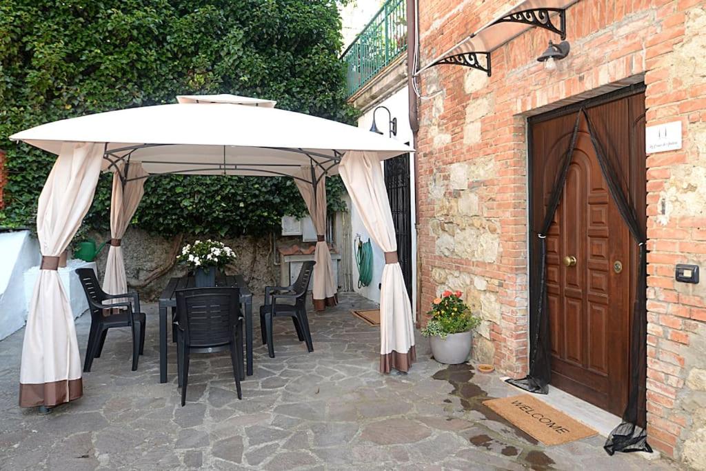 een patio met een tafel en een parasol bij La Casa di Ambra in Chianciano Terme