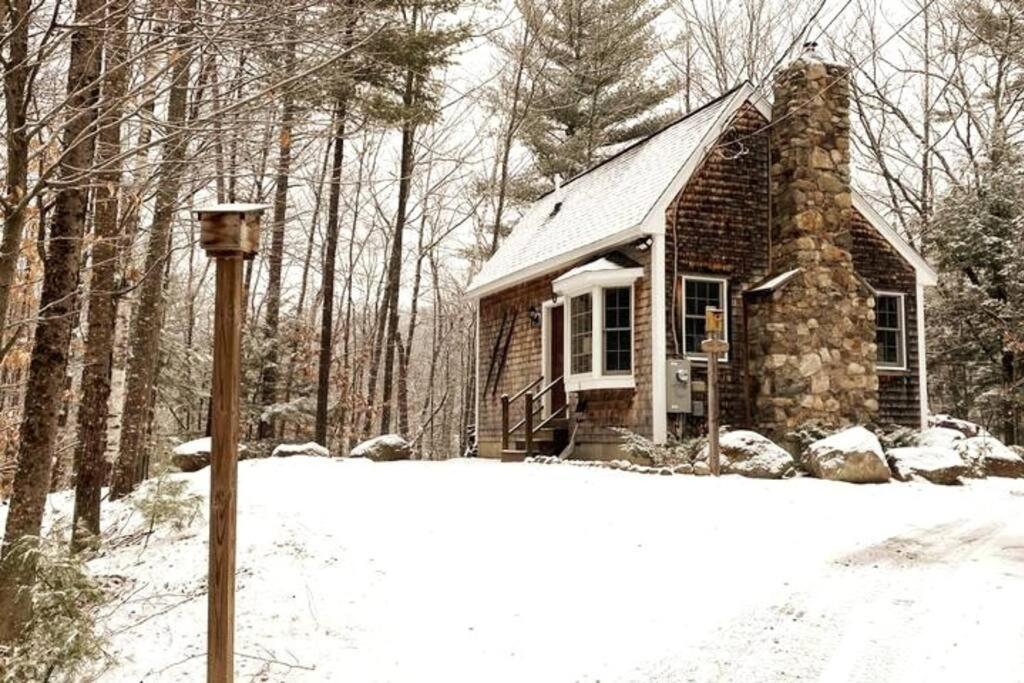 une petite maison dans la neige avec un poteau dans l'établissement Private Cabin on 1.7 acres w/ Fireplace White Mtns, à Intervale