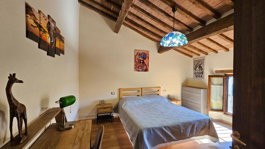 Un dormitorio con una cama y una jirafa. en La Casa del Corso en Arcidosso