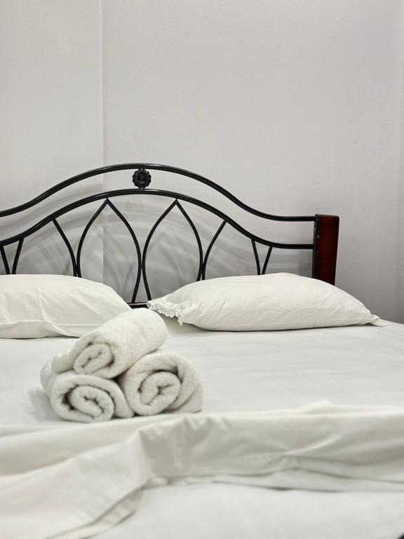 a bed with two towels on top of it at Tirana Apartment in Kashari
