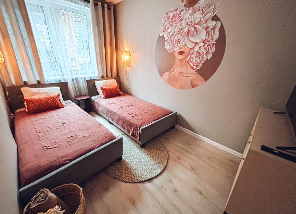 a room with two beds and a mirror on the wall at Closer Place in Tomaszów Mazowiecki