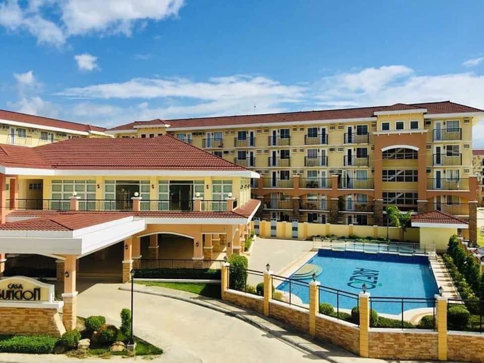 a large apartment building with a swimming pool at Cozy 1BR Condo near Airport Davao City in Davao City