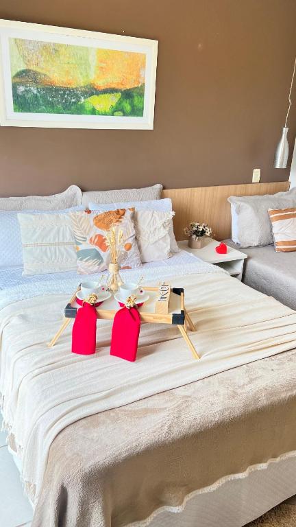 a bedroom with a large bed with two red chairs at Flat no Aldeia das Águas Park Resort in Barra do Piraí