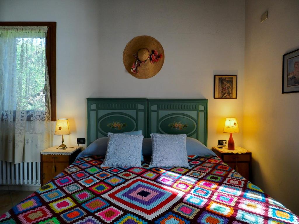 a bedroom with a bed with a colorful quilt at Agriturismo Fondo Novelle La Casina in Ferrara