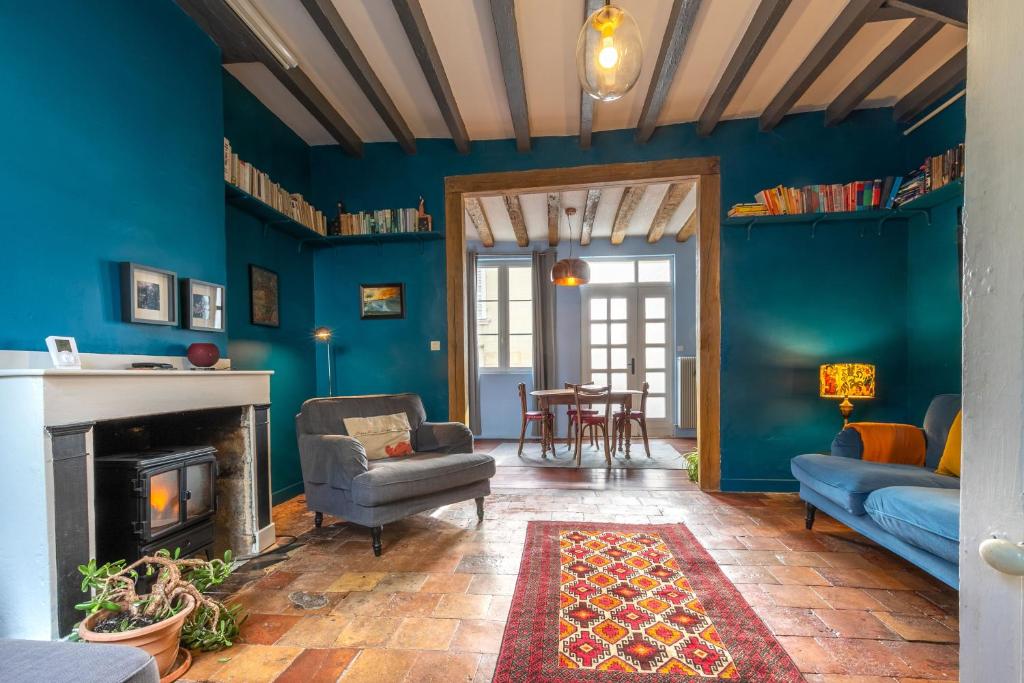 a living room with blue walls and a fireplace at Chez Miriam - Maison de caractère - Ville avec jardin in Montrichard