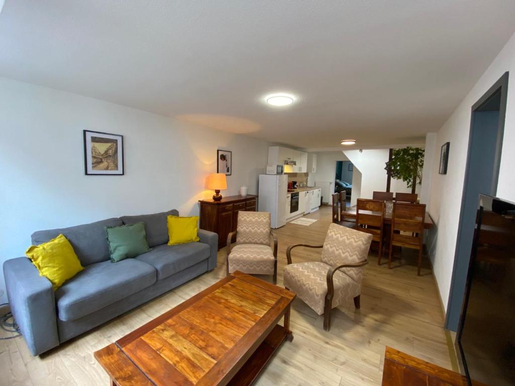 ein Wohnzimmer mit einem Sofa und einem Tisch in der Unterkunft Les Myrtilles in Barr