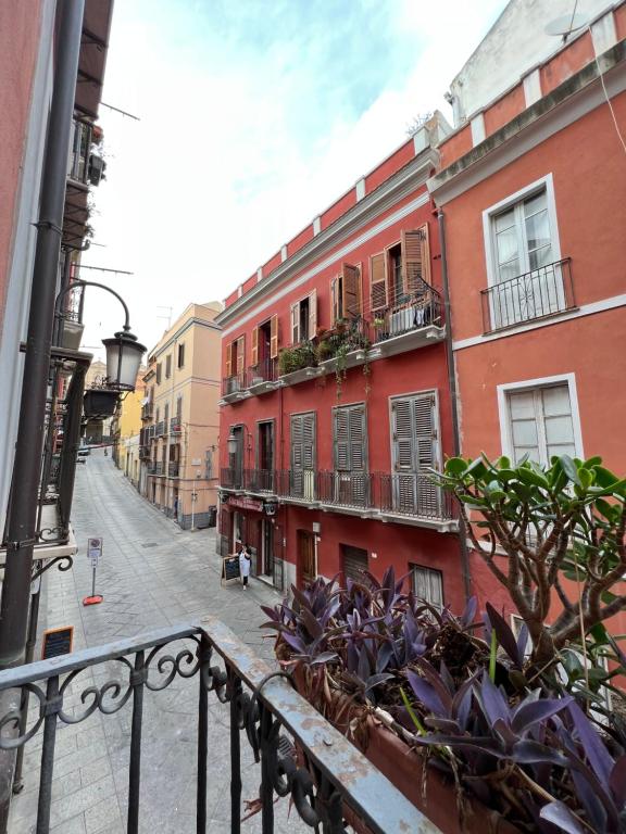 een stadsstraat met gebouwen en planten op een balkon bij Bacans - Via Azuni in Cagliari