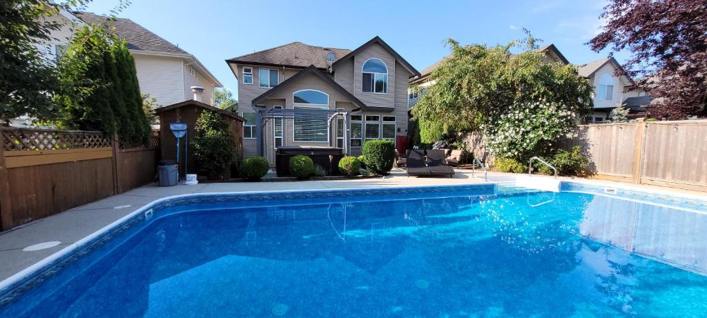 a swimming pool in front of a house at Metropolitan Dream Stay with Pool and Hot Tub in Surrey
