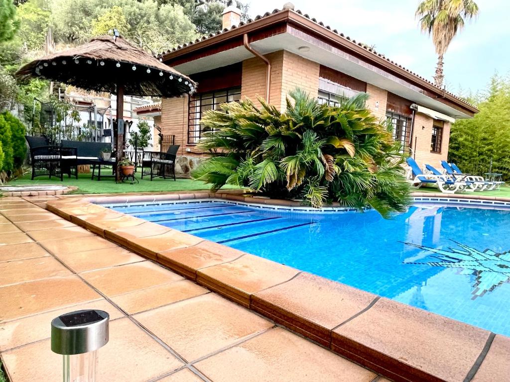 a swimming pool in front of a house at CASA PARAÍSO PISCINA TRANQUILIDAD in Sant Cebrià de Vallalta