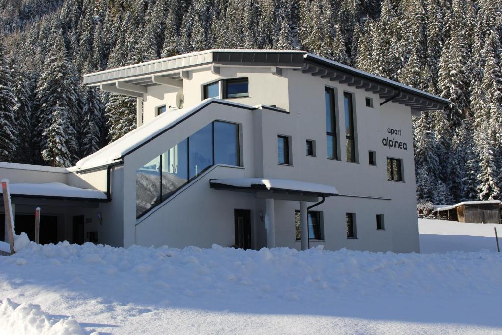ein Haus mit Schnee davor in der Unterkunft Apart Alpinea in Sankt Leonhard im Pitztal