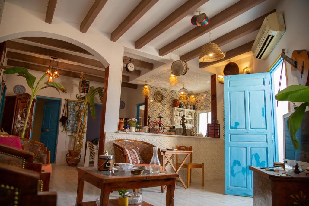 a living room with a blue door and a table at Dar Amazigh in Tozeur