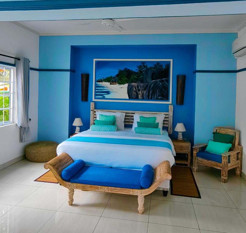 sypialnia z dużym łóżkiem i niebieskimi ścianami w obiekcie Villa Charme de L'ile w mieście La Réunion
