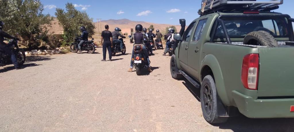 a group of motorcycles parked on a dirt road next to a truck at Panorama ait Hani Tinghir in Tinerhir