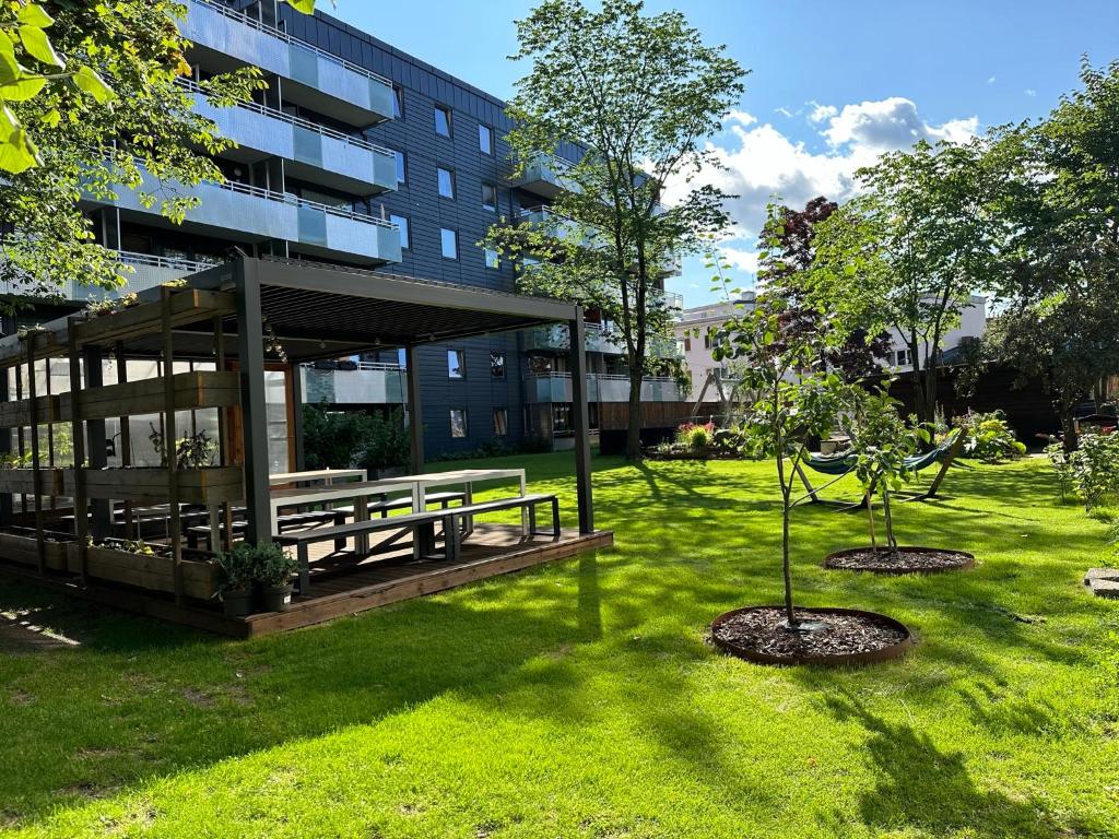 a park with two trees in front of a building at Tøyen T-bane station in Oslo